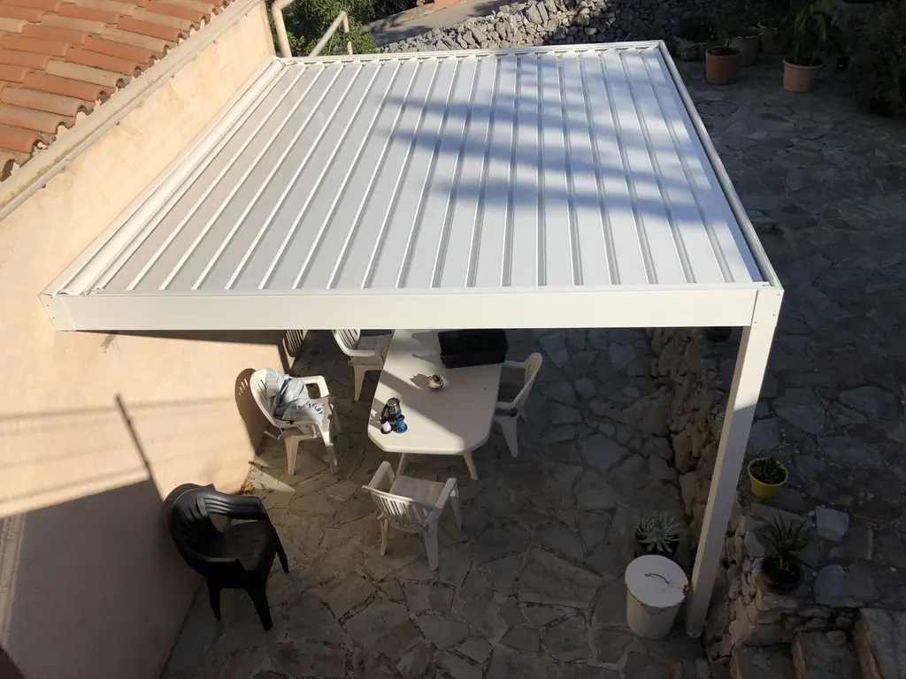 Pergola bioclimatique blanche à lames posée sur une terrasse